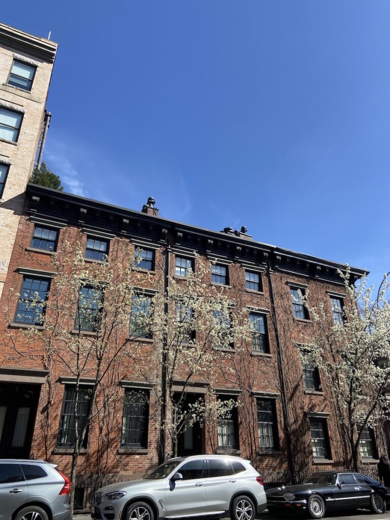 chelsea NYC brick apartment buildings with a blue sky and white flowers