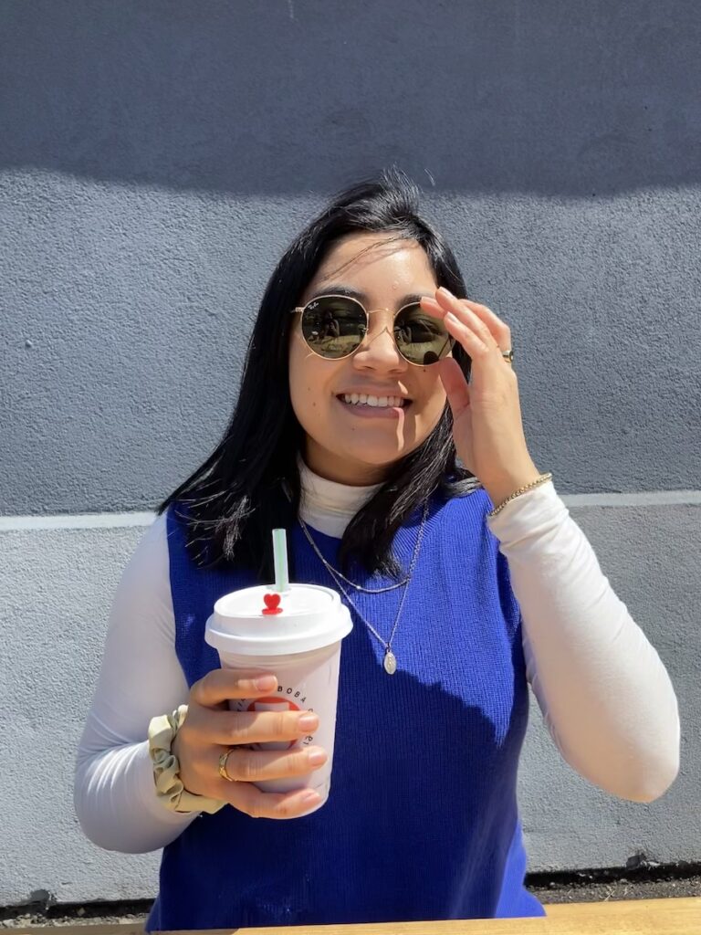 girl with black hair drinking taro boba on a sunny day